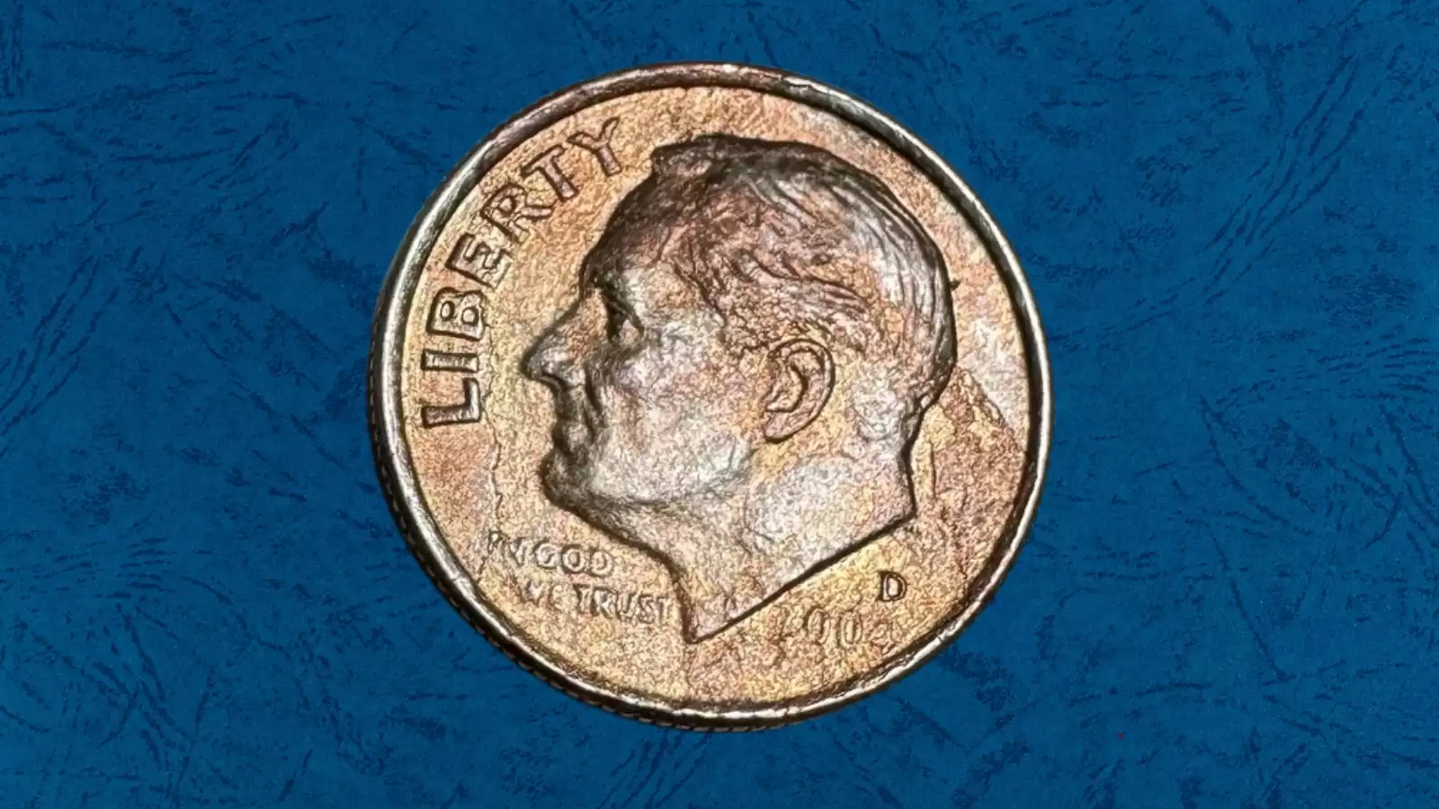 2004-D Roosevelt dime missing clad layer error showing the copper-colored inner core exposed on the obverse while the reverse retains its normal silver-nickel clad appearance